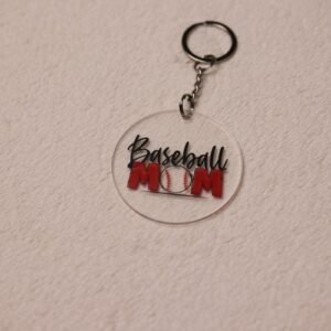 Key chain for the ultimate Baseball Mom. Clear circular disc keychain with fun "Baseball Mom" text featuring a baseball. Complete in Colby-Jack's home town Red and Black colors.