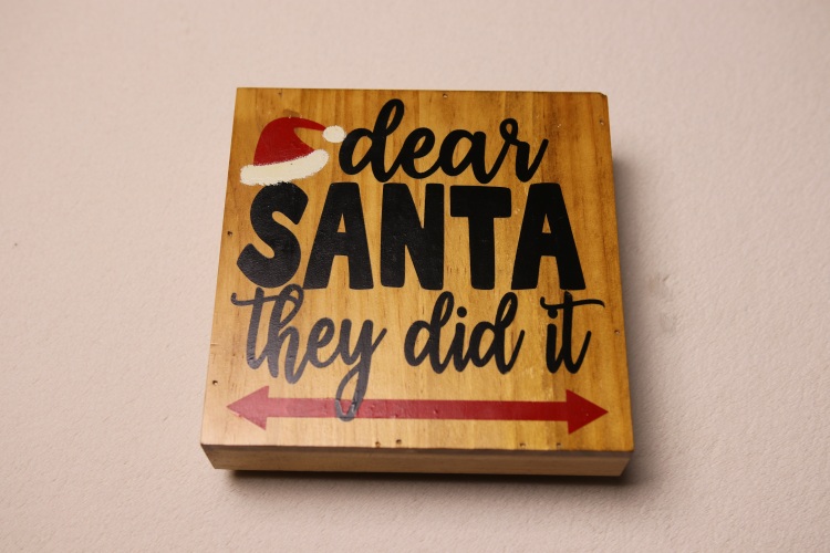 Box sign in rich oak stain for holiday cheer. Fun holiday message featuring Santa's hat.