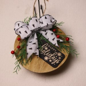 6.5 inch round wooden sign with light oak stain. Cute Christmas gift tag with "Happy holidays" in festive fonts complete with snowflake patterns. A splash of colors with pine and holly berries tied together with a white bow showing black pine trees and stitching.