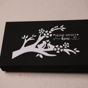 Box sign made of wood and black paint. Sign features a white painted tree branch with love birds amongst the flowers and the message "Home sweet home."