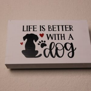 Rectangular box sign featuring a dog, paw print, and red hearts for a splash of color. "Life is better with a dog."