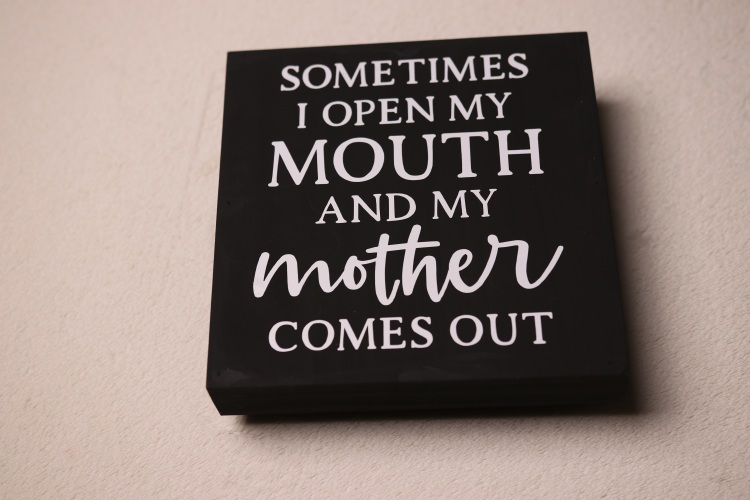 Box sign with "like mother like daughter" type saying. Black paint with fun white lettering.