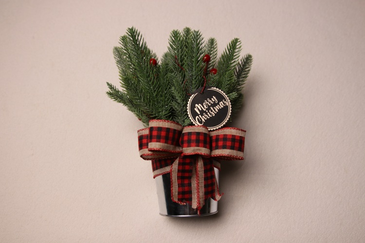 Small table-top holiday decoration. Metal pale full of faux pine needles and pine cones. Complete with cute black and silver Christmas gift tag reading "Merry Christmas" in fun festive font. Red, black, and tan checkered ribbon to complete the Christmas Cheer.