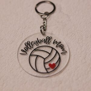 Key chain for the ultimate Volleyball Mom. Clear circular disc keychain with fun "Volleyball Mom" text. Features volleyball graphic with red heart.