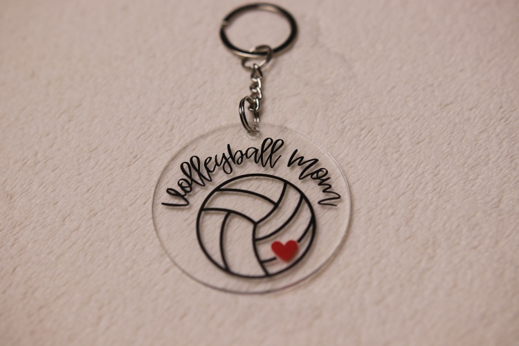 Key chain for the ultimate Volleyball Mom. Clear circular disc keychain with fun "Volleyball Mom" text. Features volleyball graphic with red heart.