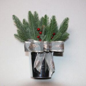 Small table-top holiday decoration. Metal pale full of faux pine needles and holly berries. Complete with holiday festive silver bow featuring glittering pine trees.